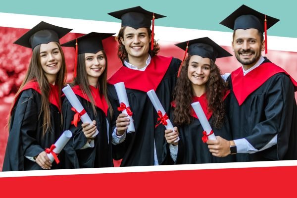Close-up of five graduates posing in front of the university